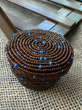 Load image into Gallery viewer, Beaded container with blue accents on a woven mat