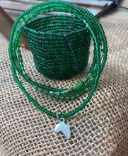 Load image into Gallery viewer, Green beaded necklace with a silver pendant on a textured surface