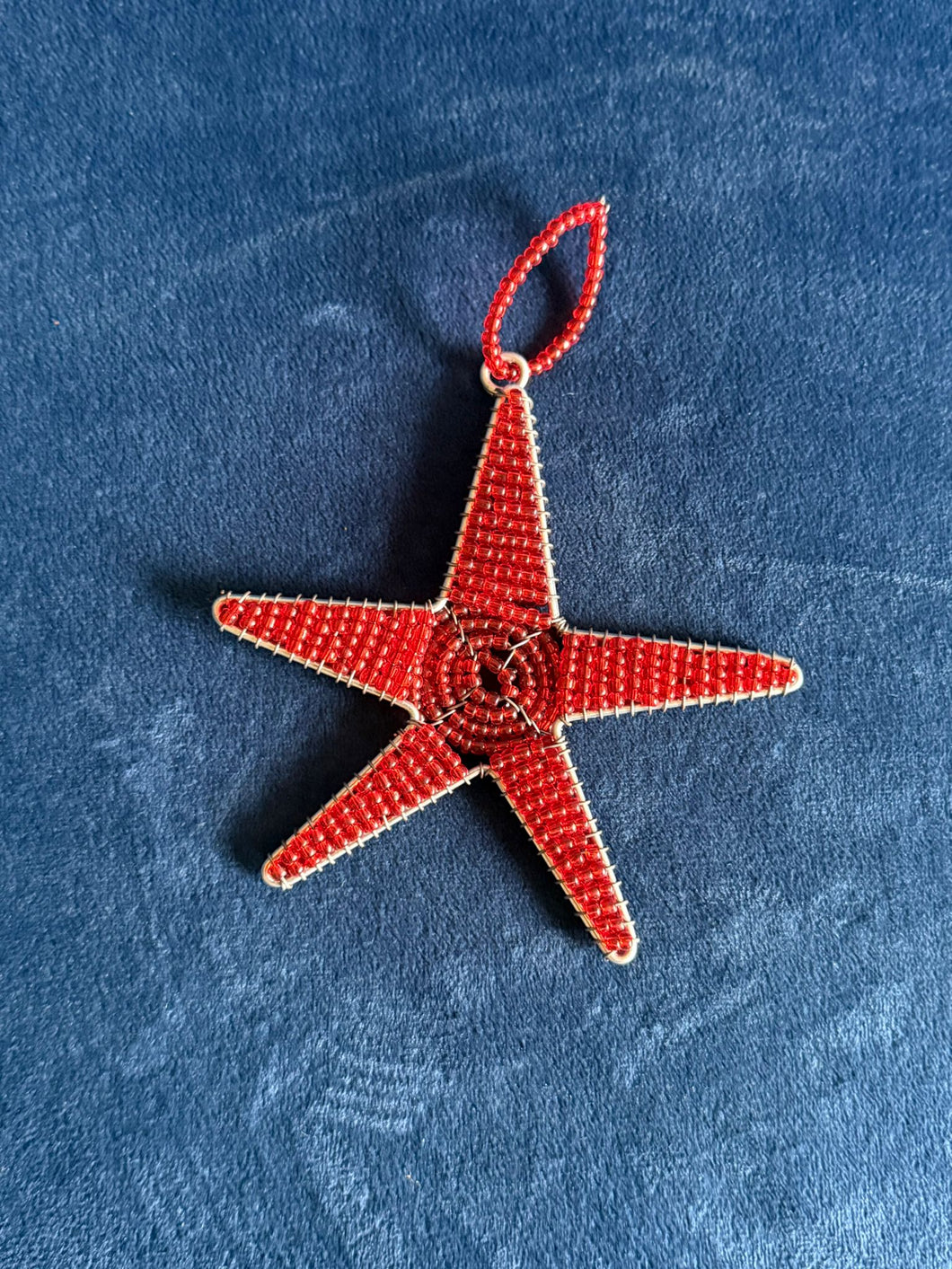 The Reach for the Stars - Tax-Deductible Honor Gift Donation with Card by Her Best Foot Forward features a handmade red beaded star ornament by East African women artisans—an ideal, unique donation gift.
