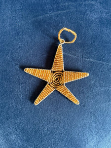 The Reach for the Stars honor gift from Her Best Foot Forward features a gold wire star ornament, handcrafted by East African women artisans. It includes a hanging loop and comes with a card; your donation is tax-deductible.