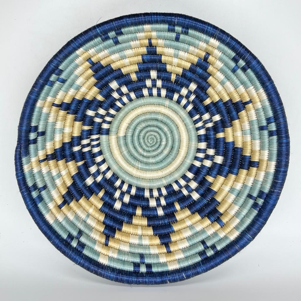 The Sunrise Handwoven Baskets by Her Best Foot Forward feature intricate, star-like blue, cream, and beige patterns. Crafted in East Africa from sweet grass, these round lids make stunning wall or table decor.